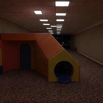 Small playground in a long dim corridor.