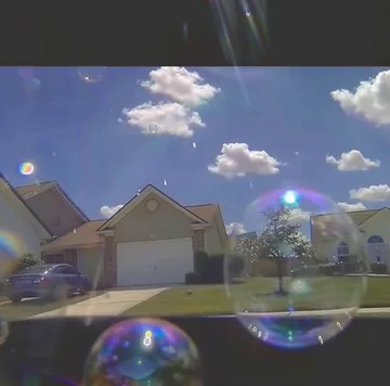 Bubbles floating in front of suburban houses.