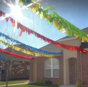 Colorful streamers above a suburban yard.
