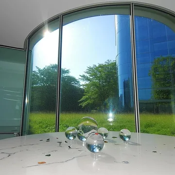 Bubbles inside an empty room with an arched glass wall.