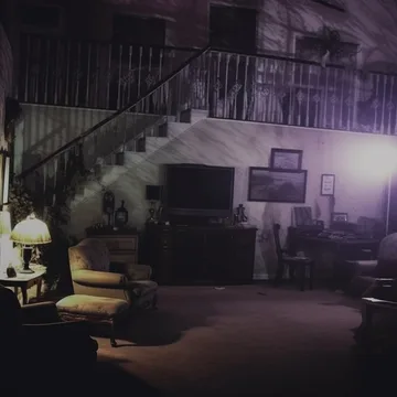 Dim living room with a staircase.