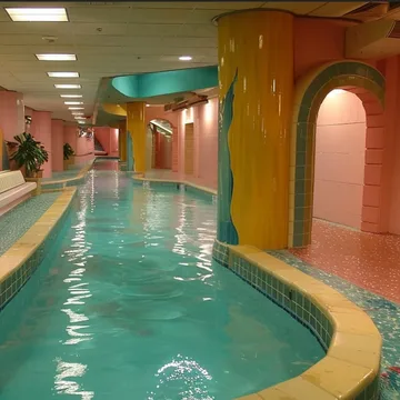 Winding indoor pool beneath colorful arches.