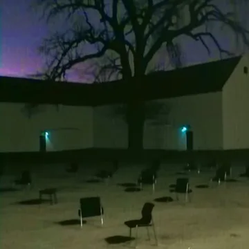 Scattered chairs in an outdoor courtyard at dusk.