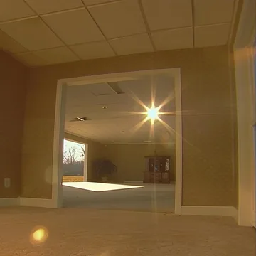 Sunlight reflected through an opening in a beige room.