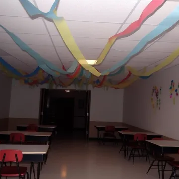 Streamers above tables in an empty classroom.