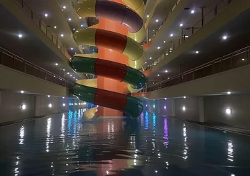 Spiral slide in a flooded apartment atrium.