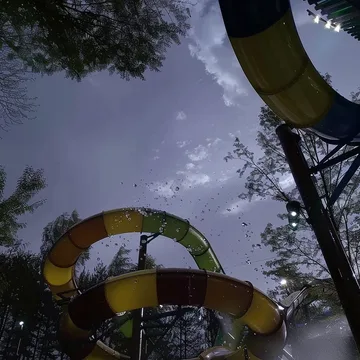 Curving water slides seen from below at dusk.