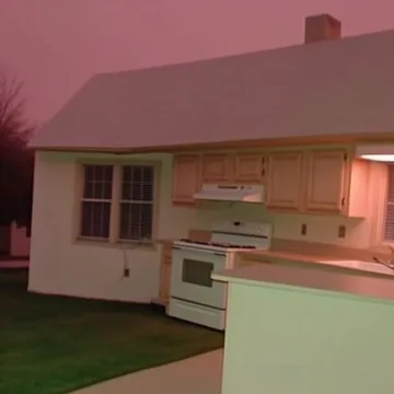 Pink kitchen opening onto a grassy lawn.