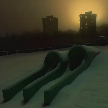 Two dark green slides beneath a yellow sky.