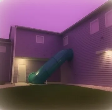 Blue slide in a pink-lit empty room.