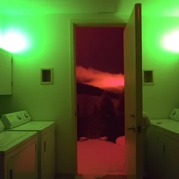 Red doorway in a green-lit kitchen.