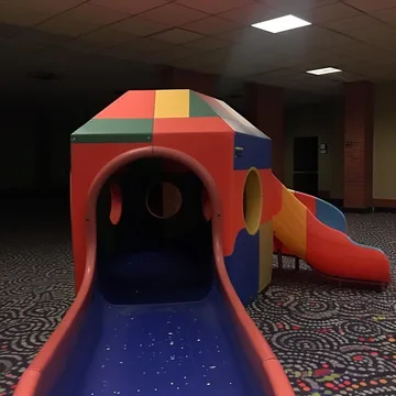 Red and orange indoor playground on patterned carpet.