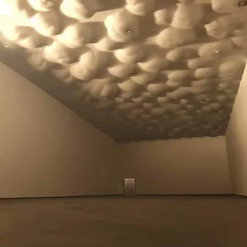 Cloud-like ceiling in an empty beige room.
