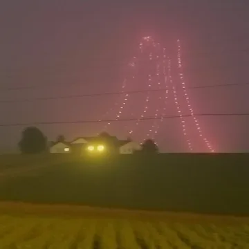 Distant houses beneath a pink patterned night sky.