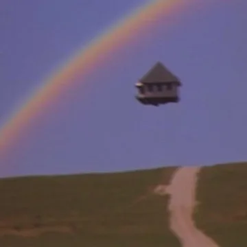 Floating house beneath a rainbow.