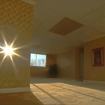 Sunlight casting long shadows in a bare room.