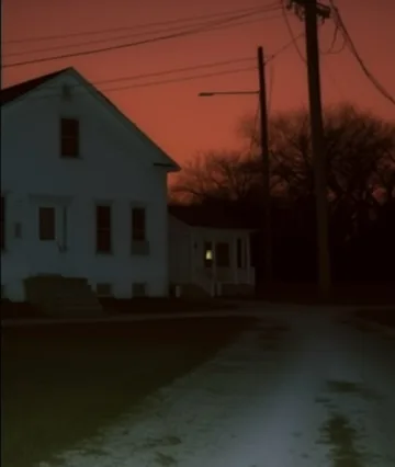 White house beside power lines at red sunset.