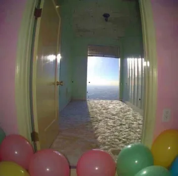 Balloons on a floor beside an open doorway.