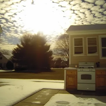Kitchen opening onto a bright yard and clouds.