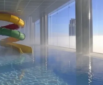Rainbow slide reflected in a blue indoor pool.