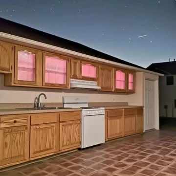 Kitchen with pink light in its windows.