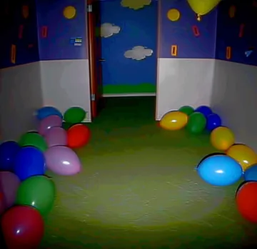 Balloons on the floor of a cloud-painted playroom.