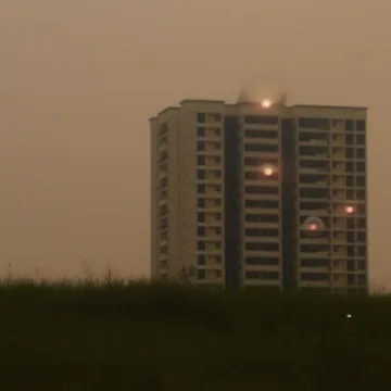 Apartment tower beneath a hazy evening sky.