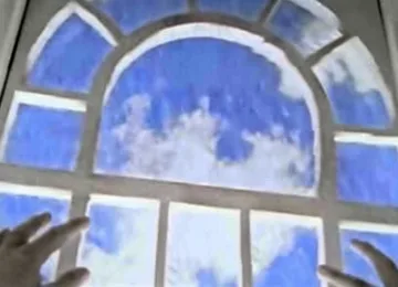 Arched window filled with blue sky and clouds.