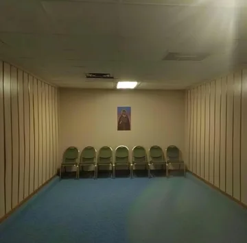 Row of green chairs in an empty room.