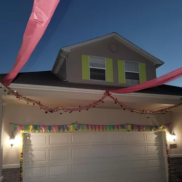 Streamers beneath an opening to a suburban house.