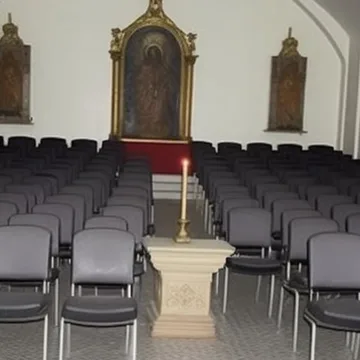 Rows of chairs facing an ornate doorway.