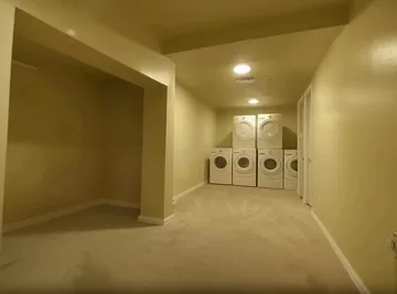Long beige corridor with repeating ceiling lights.