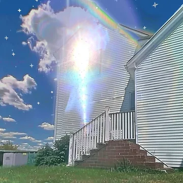 Rainbow rising beside a white house.