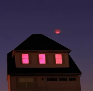 House with pink windows under a dark sky.
