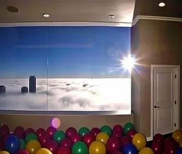 Ball pit beside a wide window above clouds.
