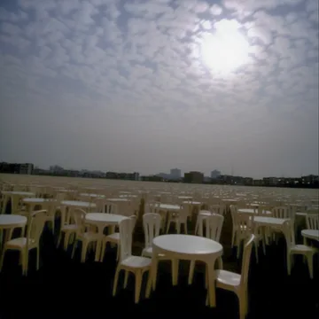 Empty outdoor tables beneath a textured gray sky.