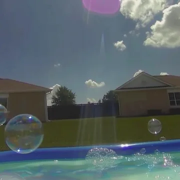 Bubbles above water outside suburban houses.