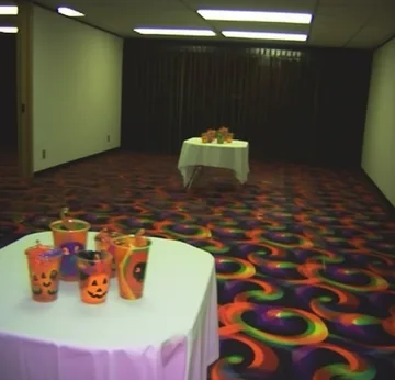 Party table and white chair on colorful carpet.