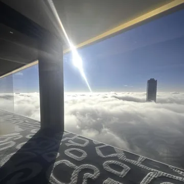 Sunlight across a patterned walkway above clouds.