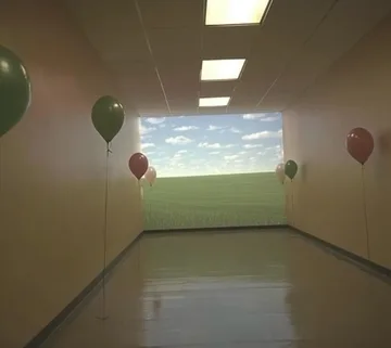 Balloons in a bright empty hallway.