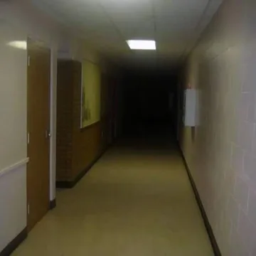 Narrow yellow corridor leading into shadow.