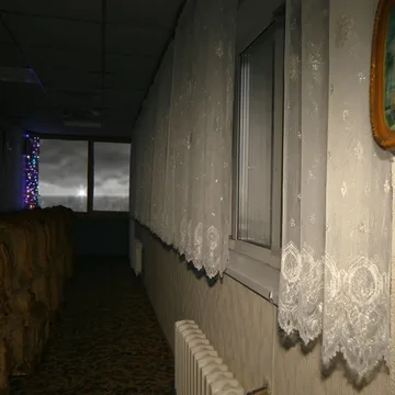 Lace curtains along a dark corridor.