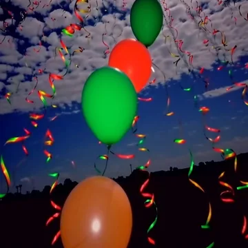 Balloons and confetti beneath a textured sky.
