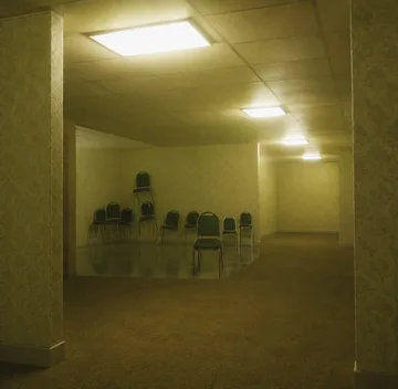 Row of chairs in a dim yellow room.