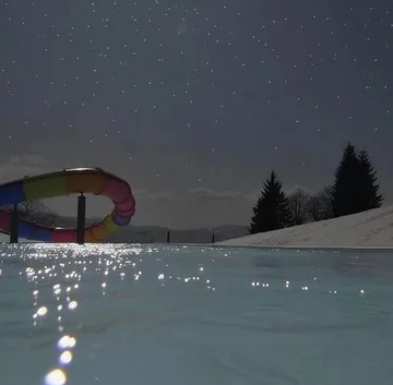 Moonlight sparkling on an outdoor pool.